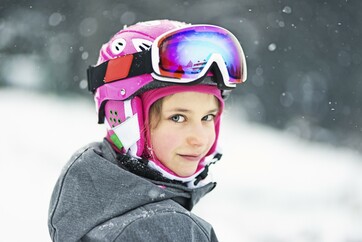 Young woman on ski hill smiling at camera